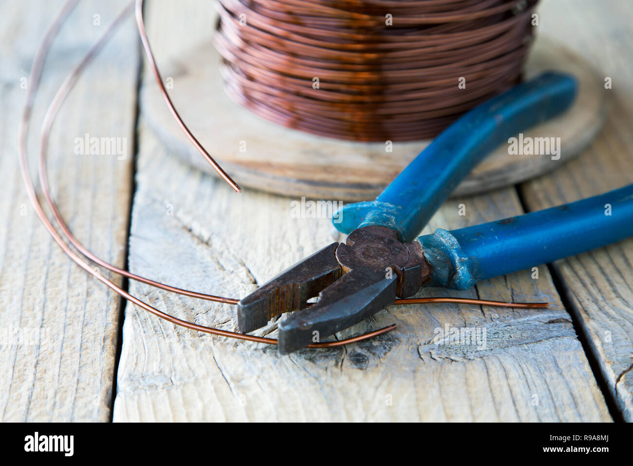 coil of copper wire and pliers close-up Stock Photo