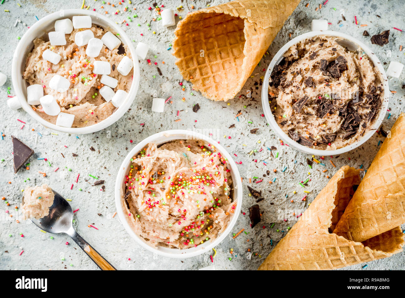 Edible Raw Cookie Dough, sweet modern dessert, with waffle ice cream cones on grey stone background, copy space Stock Photo