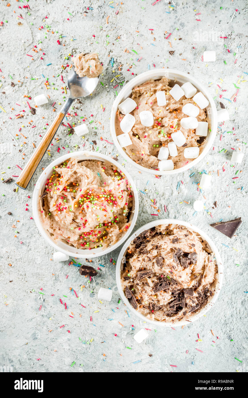 Edible Raw Cookie Dough, sweet modern dessert, with waffle ice cream cones on grey stone background, copy space Stock Photo