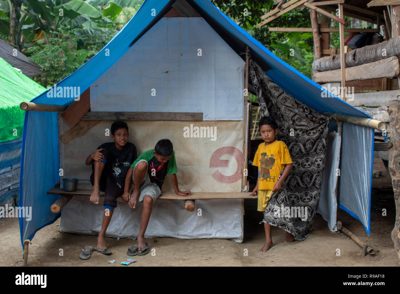 Palu, Indonesia, December 21, 2018: Residents affected by the disaster move outside their tents in the refugee camp of Toaya Vunta Village, Donggala, Central Sulawesi, Indonesia, Friday (December 21, 2018). After entering a period of recovery, refugees with a total of 120 heads of household in the area began to lack food due to the reduction in aid and in the meantime, refugees had lost their jobs due to the earthquake and tsunami that hit their settlements on 28 September 2018. Stock Photo