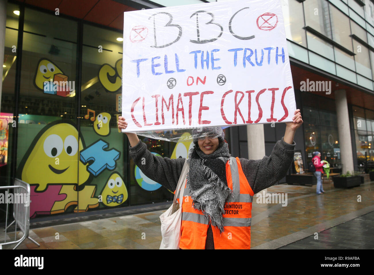 Salford, UK. 21st Dec, 2018. An Extinction Rebellion campaigner holding a placard which reads "BBC Tell The Truth on Climate Change". BBC, Media City, Salford, UK, 21st December 2018 (C)Barbara Cook/Alamy Live News Credit: Barbara Cook/Alamy Live News Stock Photo