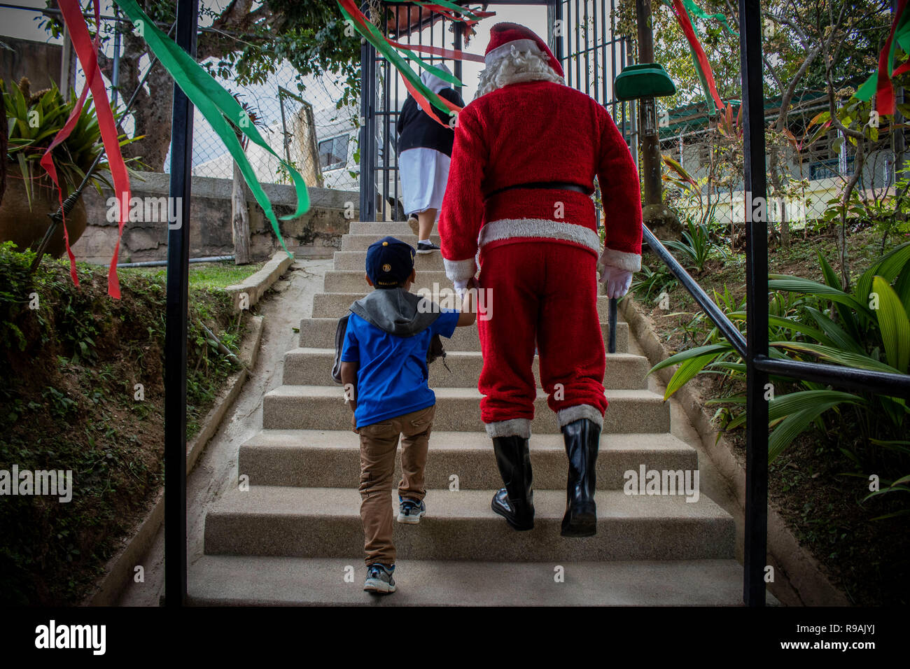 Caracas, Venezuela. 21st Dec, 2018. 'Santa Claus' comes to a congregation in the countryside east of Caracas and brings gifts to children through the initiative 'Un Juguete: Una Buena Noticia' (A Toy, a Good News). The initiative was founded by reporters and journalists in Venezuela. The group also provides school supplies for children from a poorer neighbourhood in Caracas. Credit: Rayner Pena/dpa/Alamy Live News Stock Photo