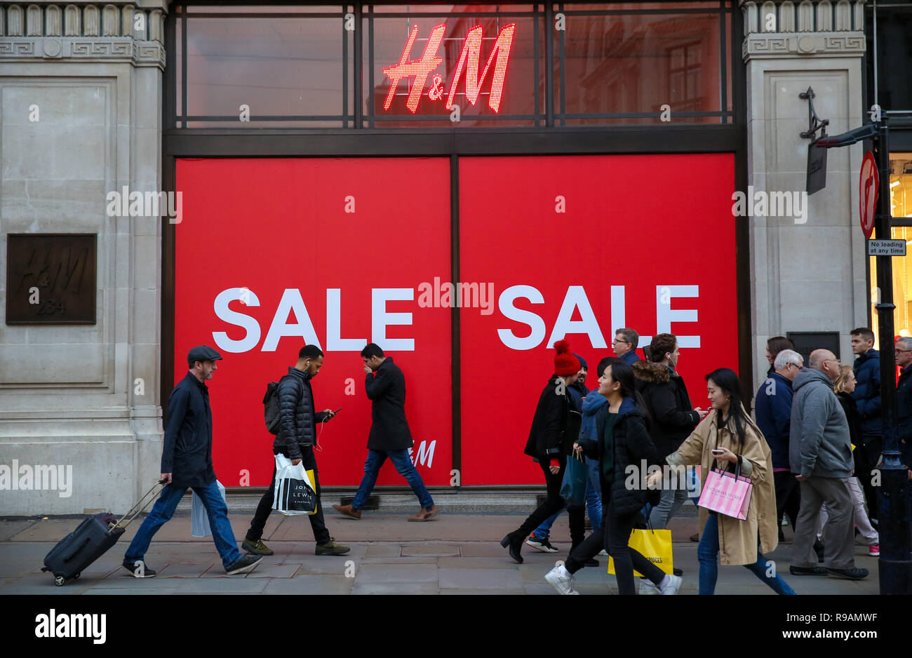 Regent Street, London, UK. Shoppers are seen walking past a large SALE sign  in H&M window display on London Regent Street as the winter sales begin.  Credit: SOPA Images Limited/Alamy Live News