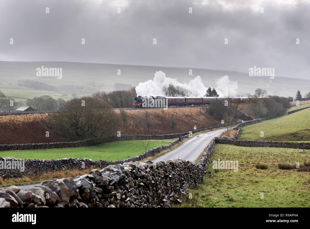 Horton-in-Ribblesdale, North Yorkshire, UK. 22nd December, 2018. Through squally rain The Flying Scotsman steam locomotive hauls the 'Christmas Dalesman' on a round trip from Manchester. Travelling on the famous Settle-Carlisle railway line, the train is seen here at Horton-in-Ribblesdale in the Yorkshire Dales National Park, on its way to Carlisle. Credit: John Bentley/Alamy Live News Stock Photo
