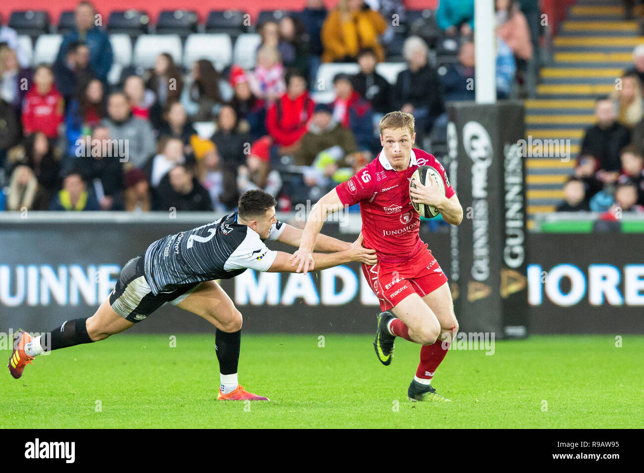 Scarlets left wing Johnny McNicholl on the attack in the Guinness Pro14 rugby match between Ospreys and Scarlets. Stock Photo