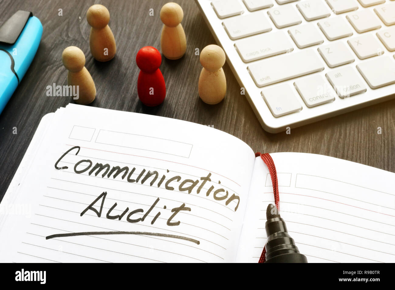 Communication audit written in a note and wooden figures. Stock Photo