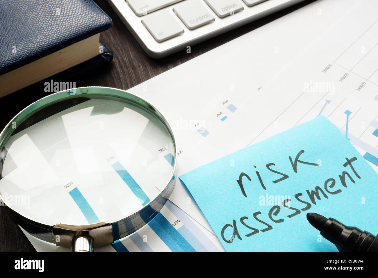 Risk assessment. Magnifying glass and documents on a table Stock Photo