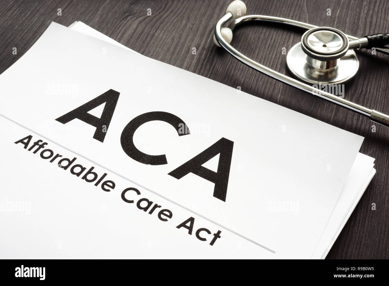 Affordable Care Act ACA and stethoscope on a wooden desk. Stock Photo