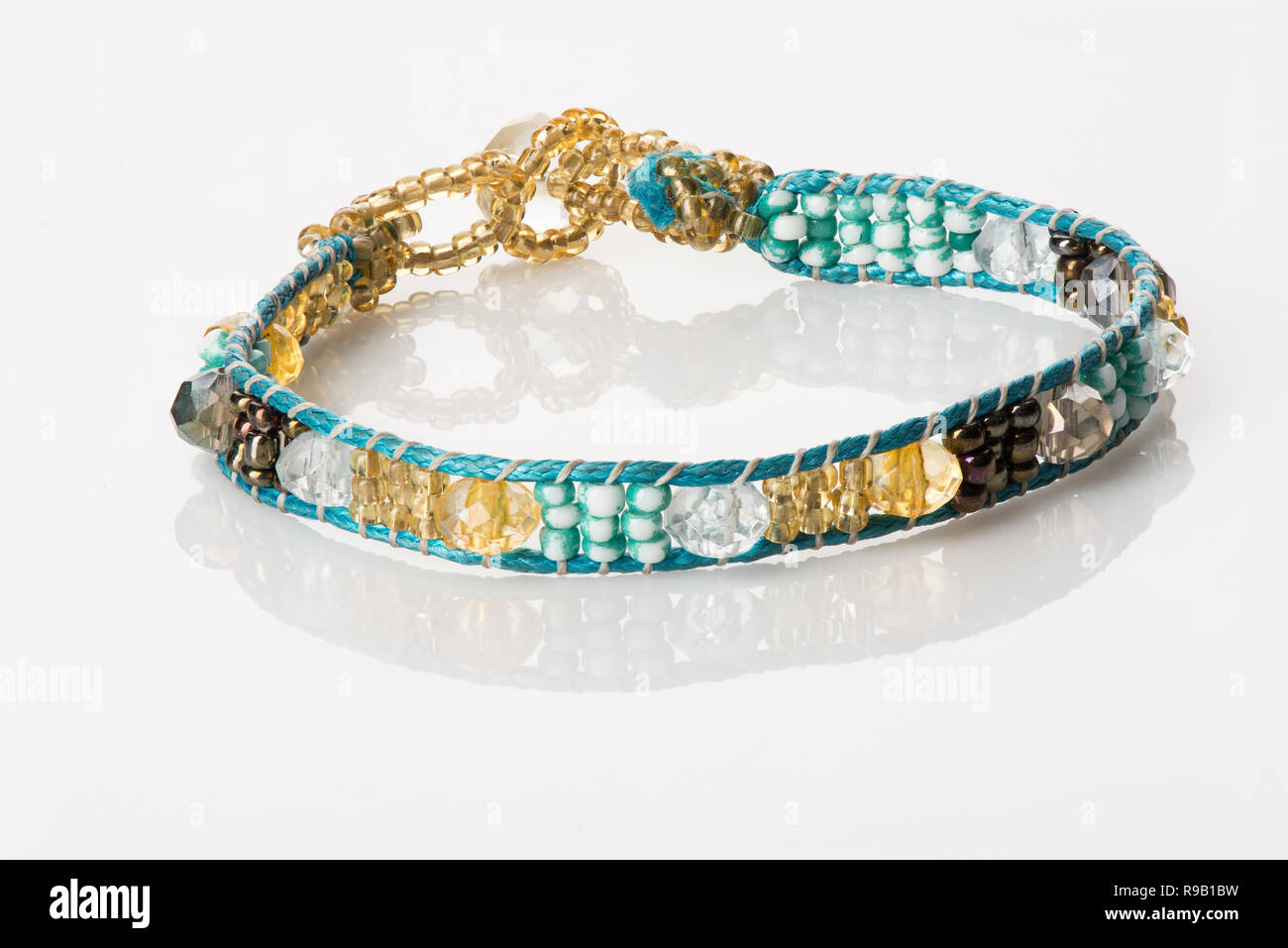 Women's Beaded Bracelet - Turquoise & Gold, on white with reflection Stock Photo