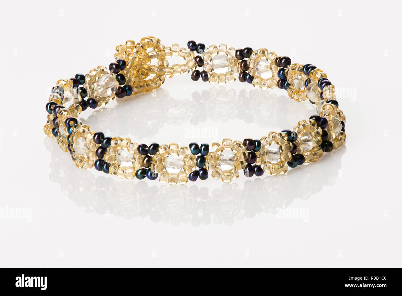 Women's Beaded Bracelet - Gold and Navy Blue, on white with reflection Stock Photo