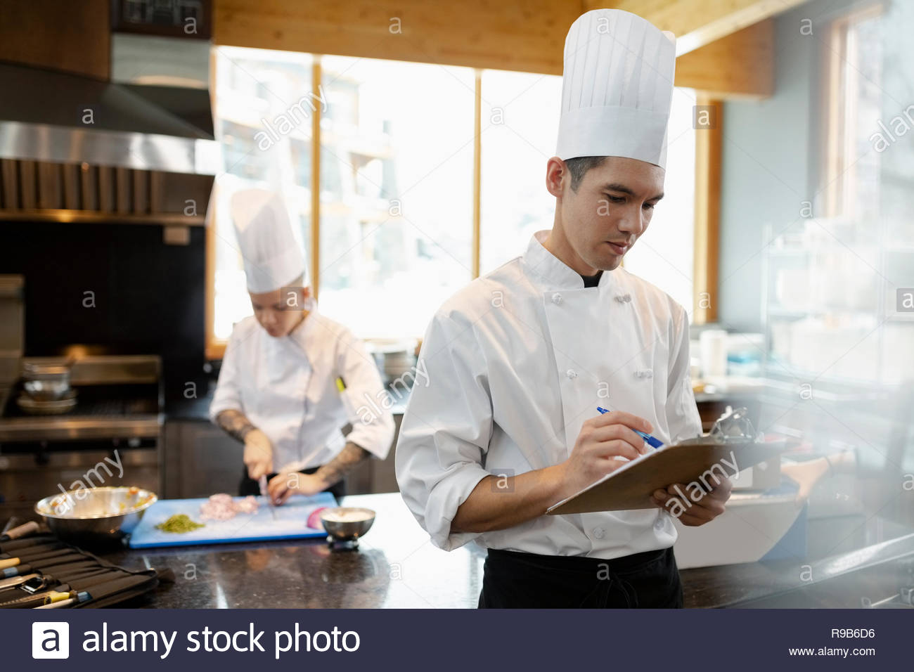 Executive chef and prep cook cooking and planning in restaurant kitchen Stock Photo
