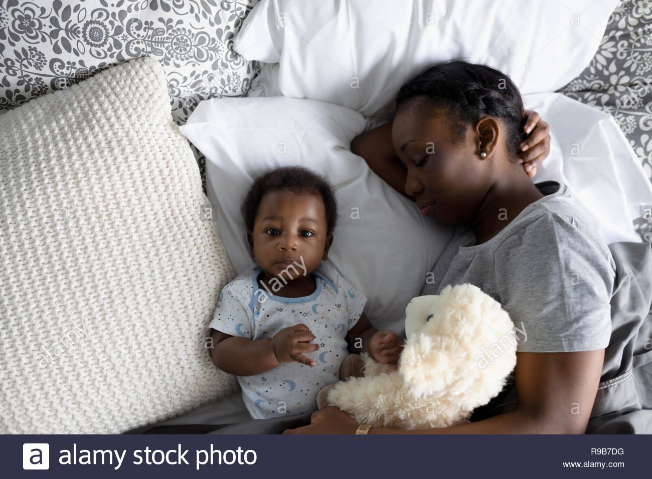 View from above mother and baby son napping on bed Stock Photo