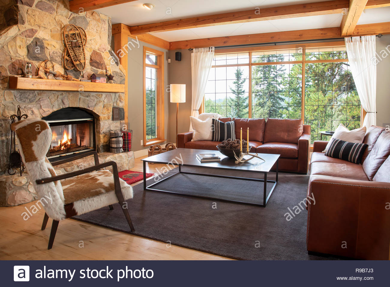 Home showcase interior living room with leather sofas and stone fireplace Stock Photo