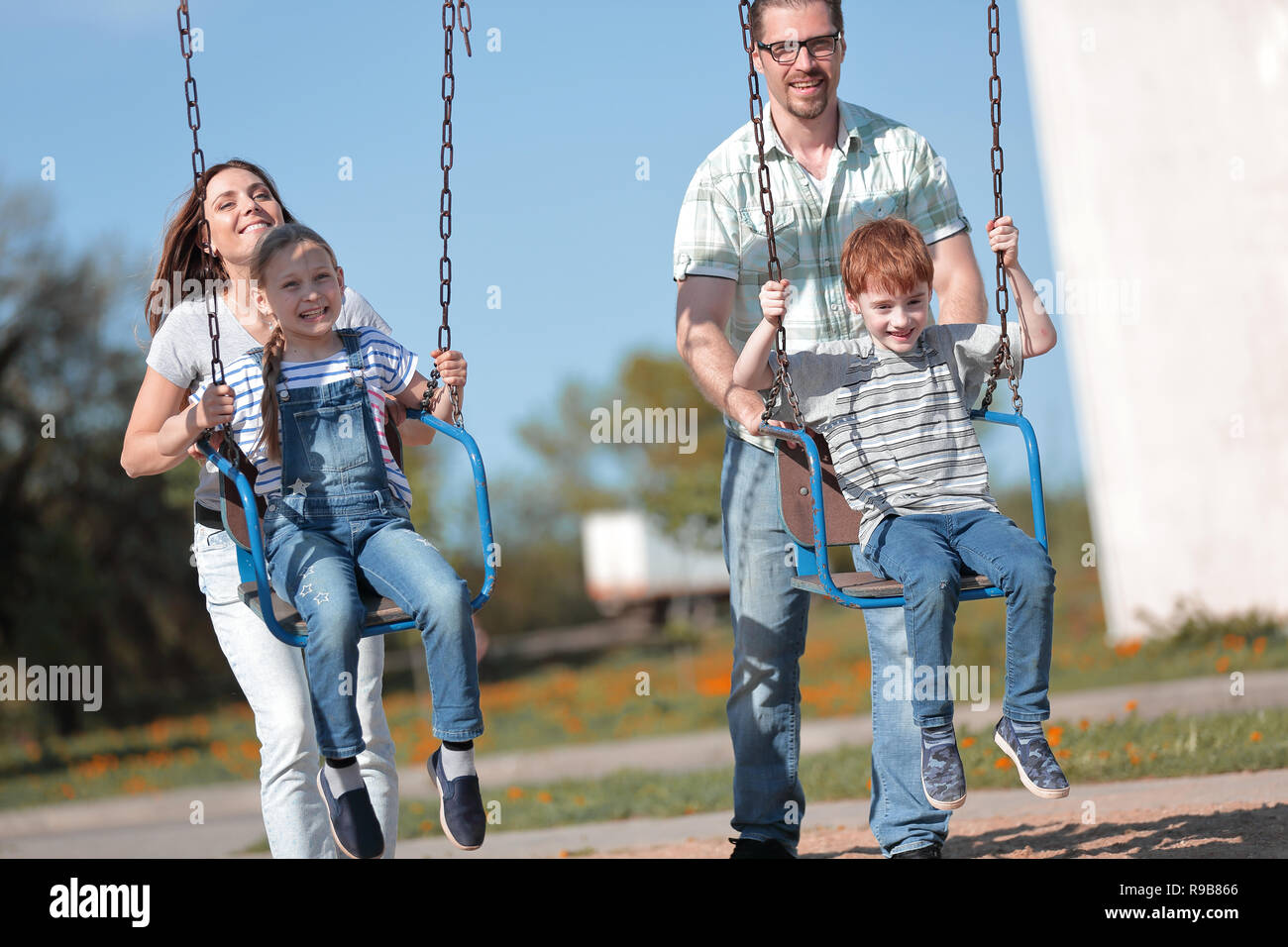 couple with two children playing in the Playground Stock Photo
