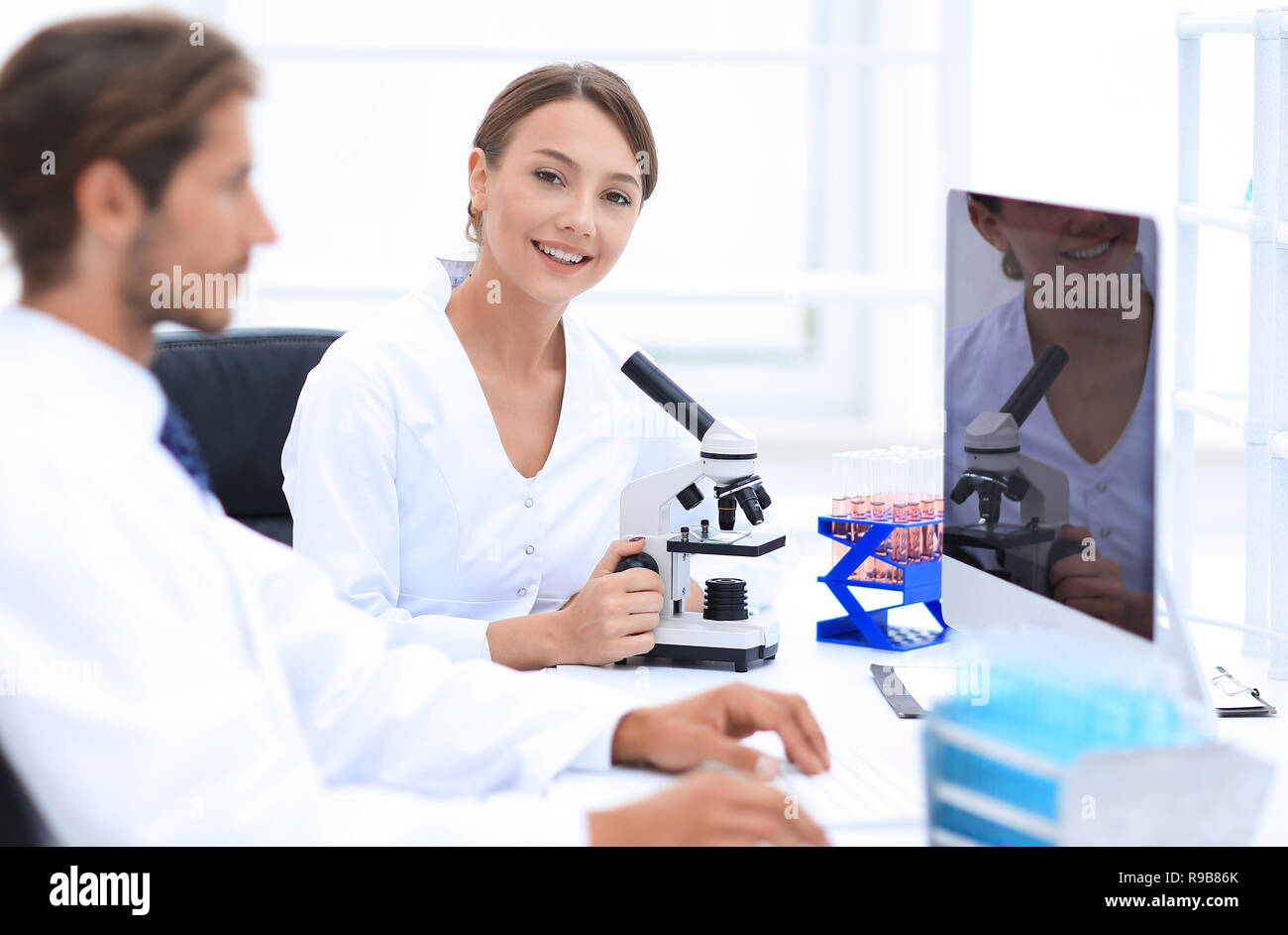 Lab expert working on a test using microscope Stock Photo