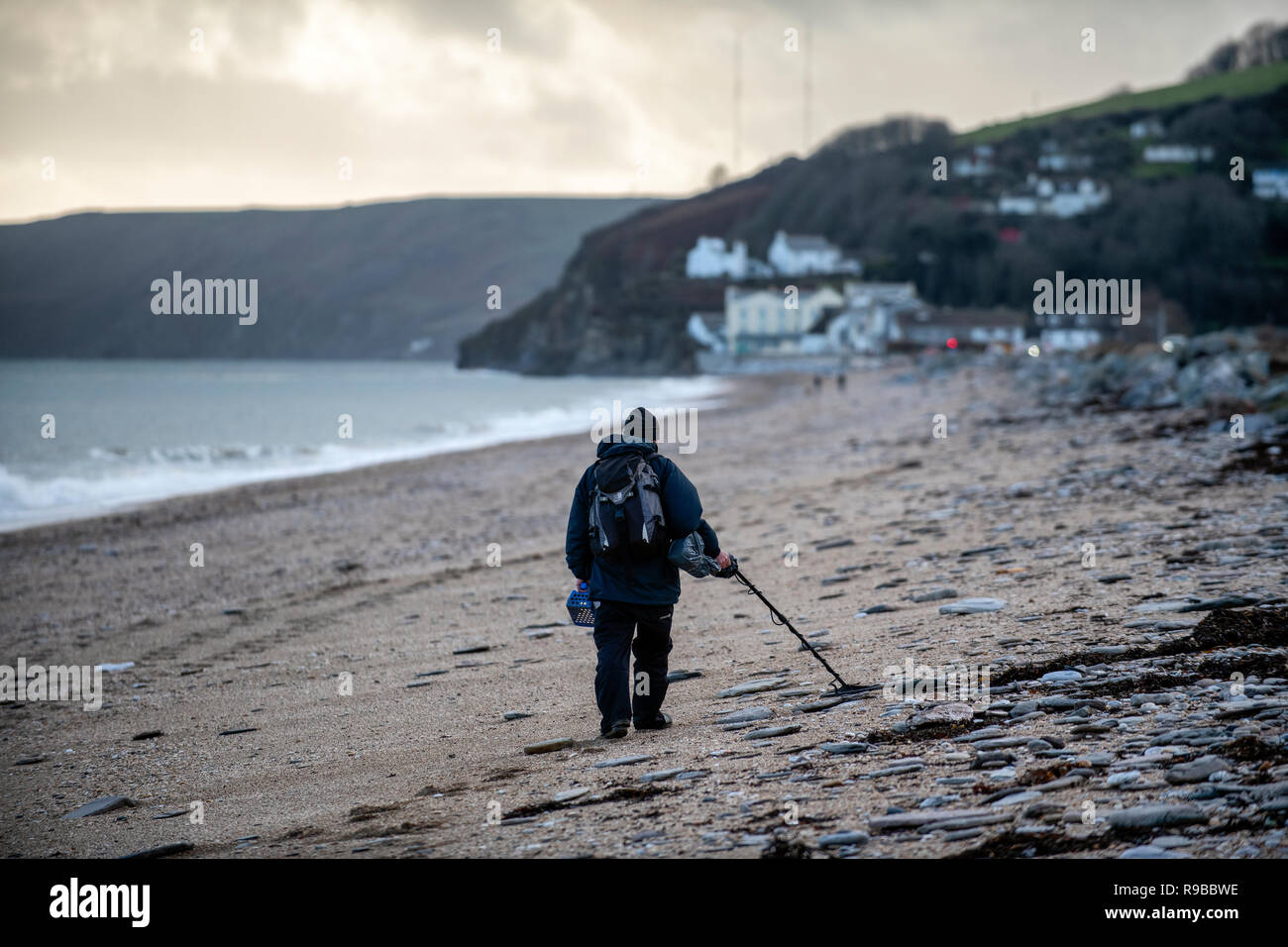 Metal detectorist on Slapton sands beach in Devon, United Kingdom Stock