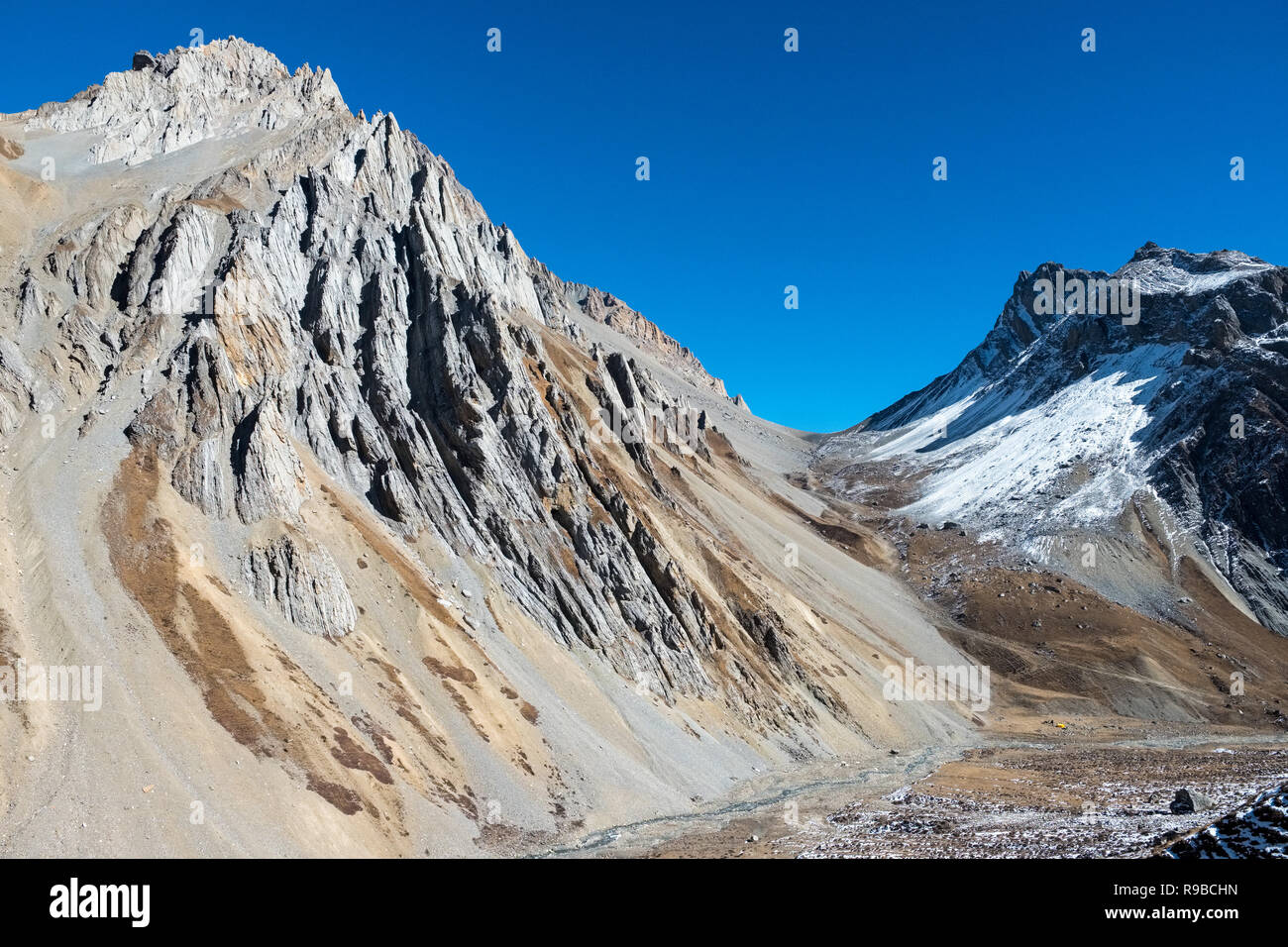 Arid, glaciated mountain terrain on the Tibet / Nepal border of the Himalayas Stock Photo