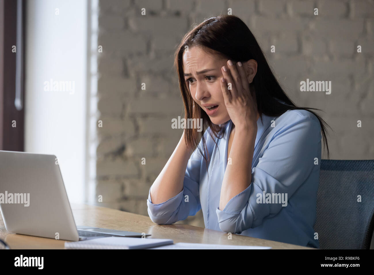 Shocked woman feels desperate reading bad online email news Stock Photo