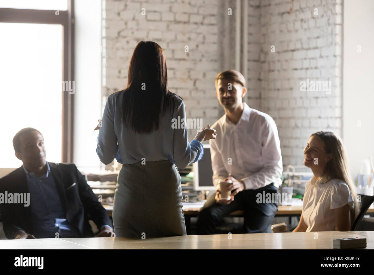Rear view at female leader speaking at diverse group meeting Stock Photo