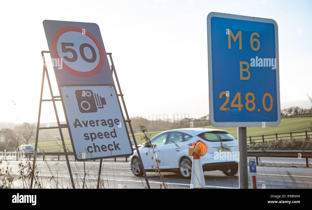 A car passes motorway signs and enters an Average Speed Check area Stock Photo