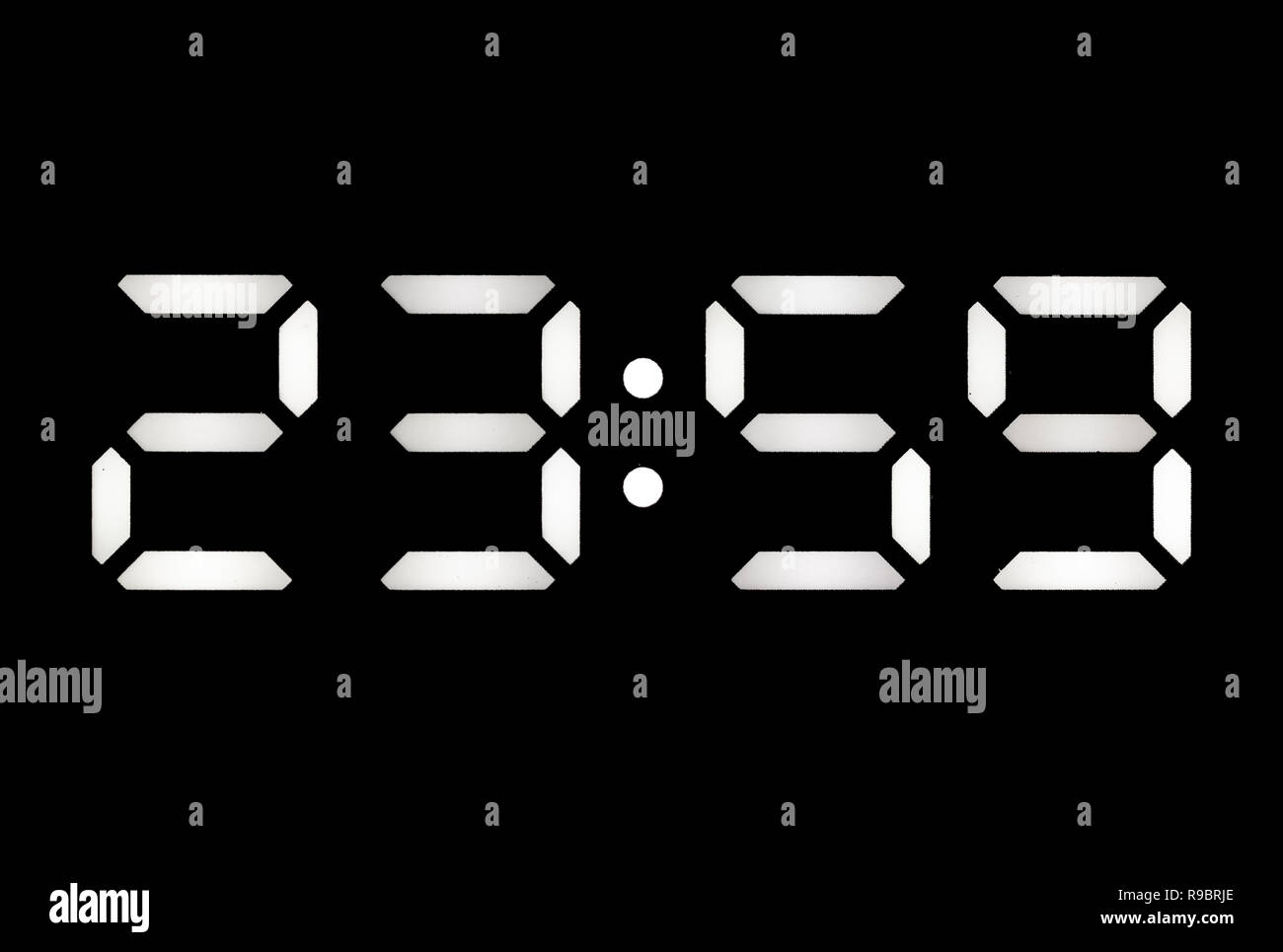 Real White Led Digital Clock On A Black Background Showing Time 23 59 real-white-led-digital-clock-on-a-black-background-showing-time-23-59