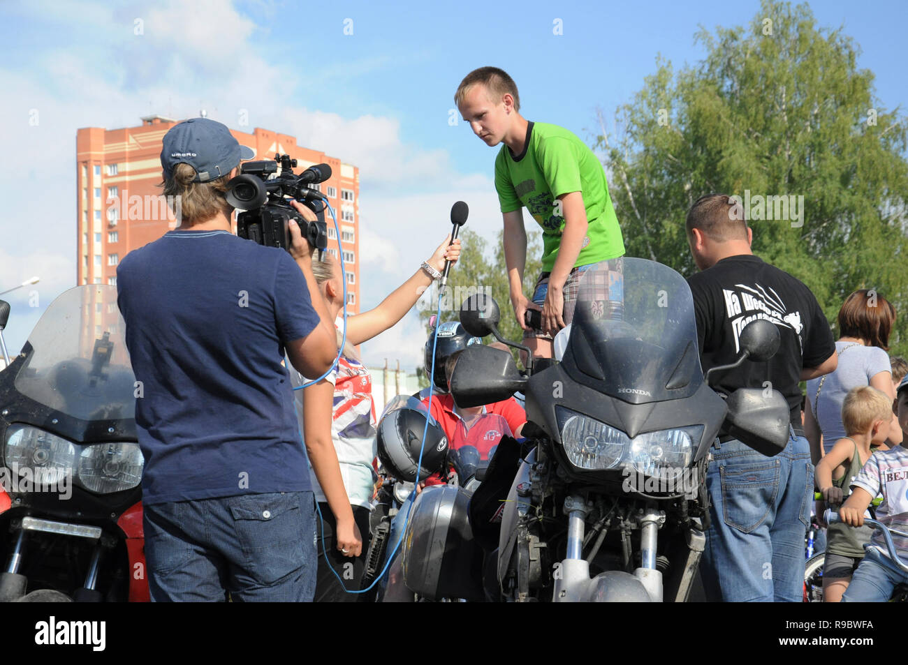 Kovrov, Russia. 9 August 2014. Sports holiday 'Velobum', devoted to Day of the athlete. Participants the bike show gives interview to local TV Stock Photo