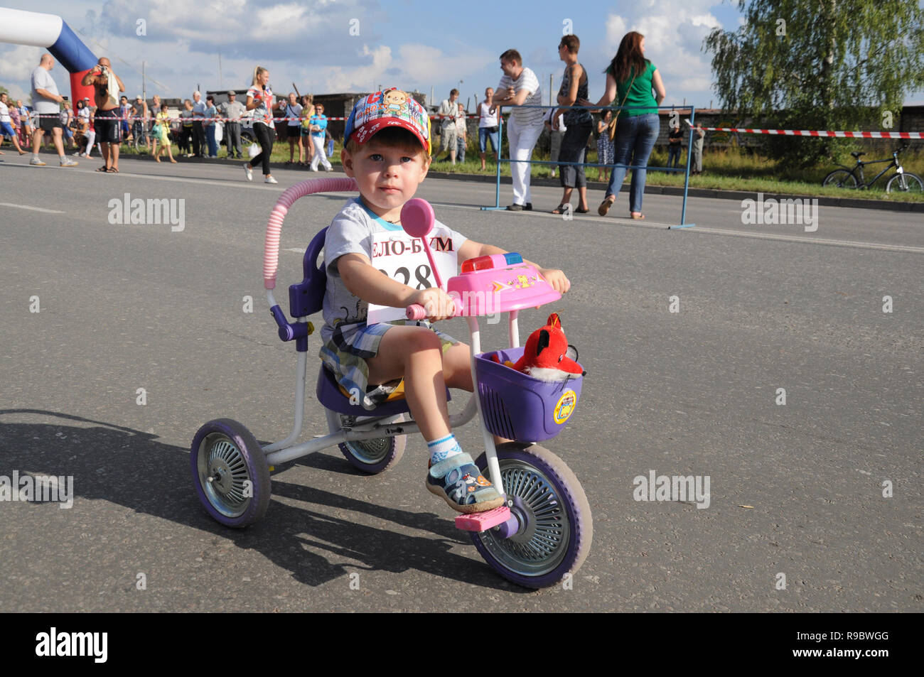 Kovrov, Russia. 9 August 2014. Sports holiday 'Velobum', devoted to Day of the athlete. Participant in the youngest age group on tricycle starts the r Stock Photo