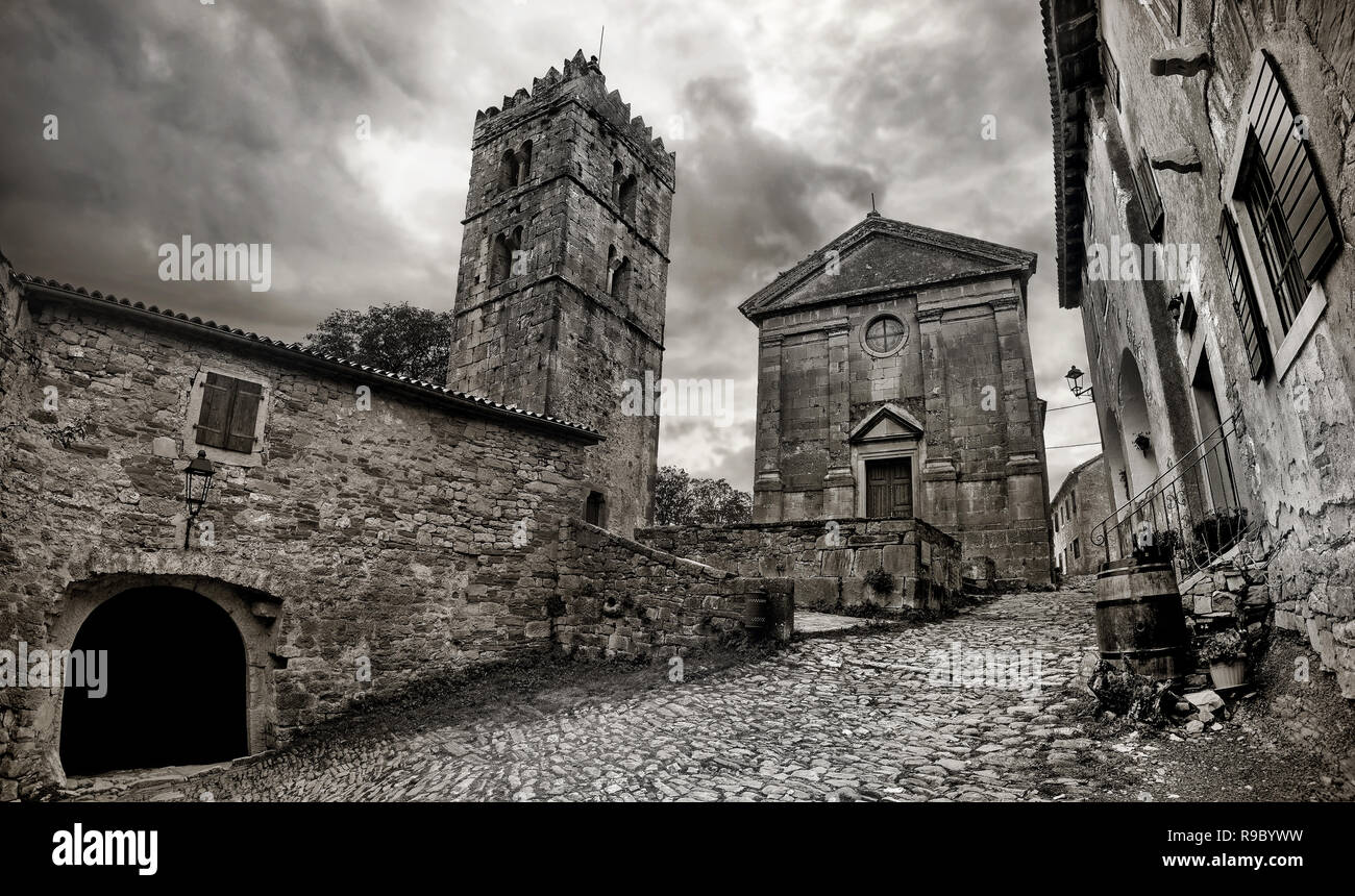 Cityscape of Hum town with cobbled street and church. Smallest city in the world. Black and white color. Istria, Croatia Stock Photo