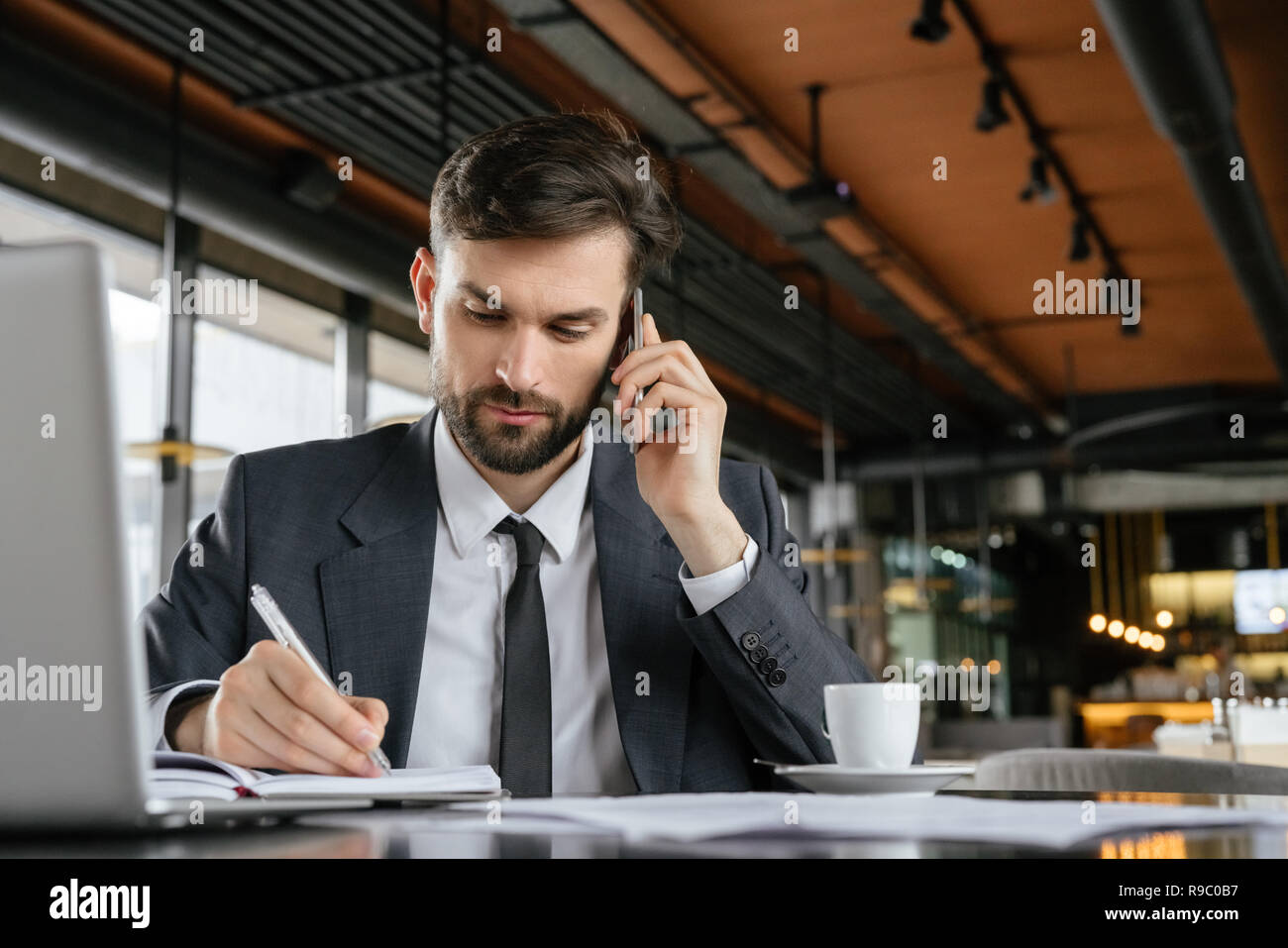 Businessman on business lunch at restaurant sitting at table talking on