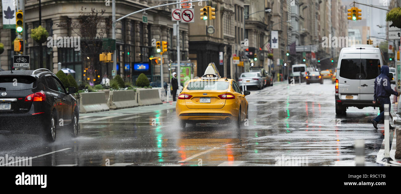 Cars and taxis travel the 5th avenue on a cold and rainy day. Manhattan, New York City, United States. Stock Photo