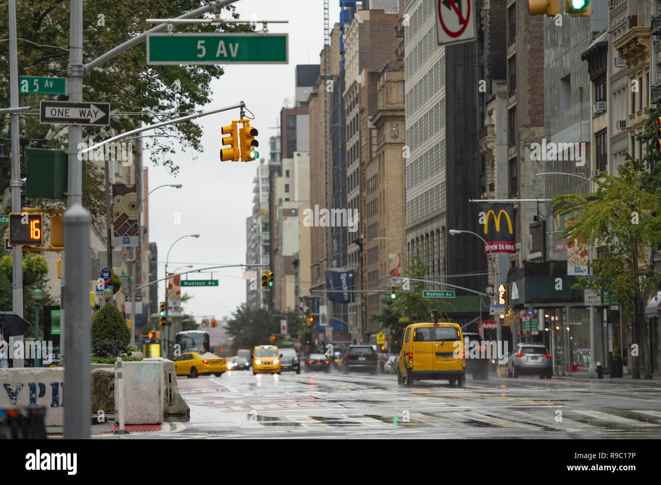 Cars and taxis travel the 5th avenue on a cold and rainy day. Manhattan, New York City, United States. Stock Photo