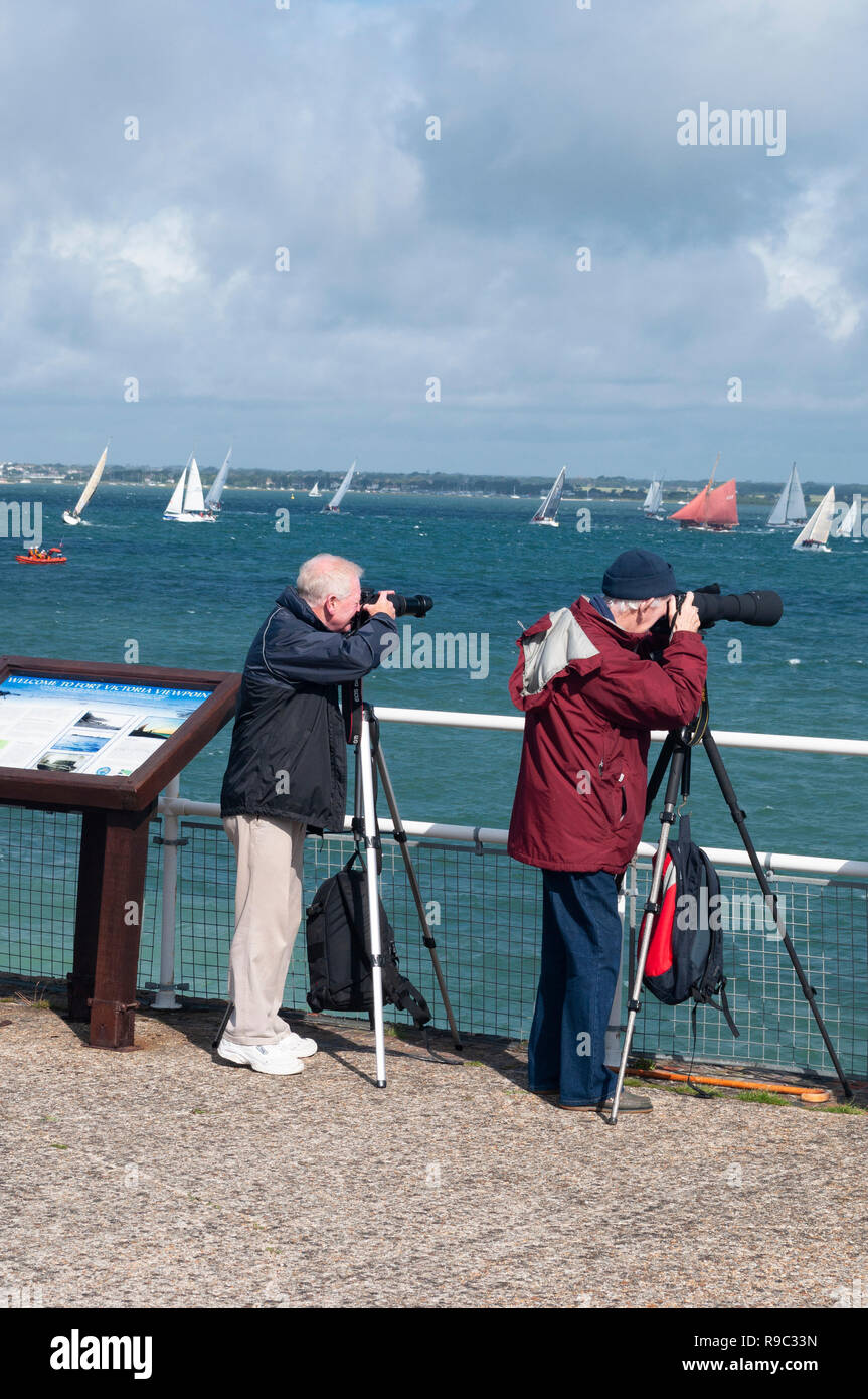 Two elderly men photographing the Round The Island Race at Fort Victoria, Isle of Wight Stock Photo