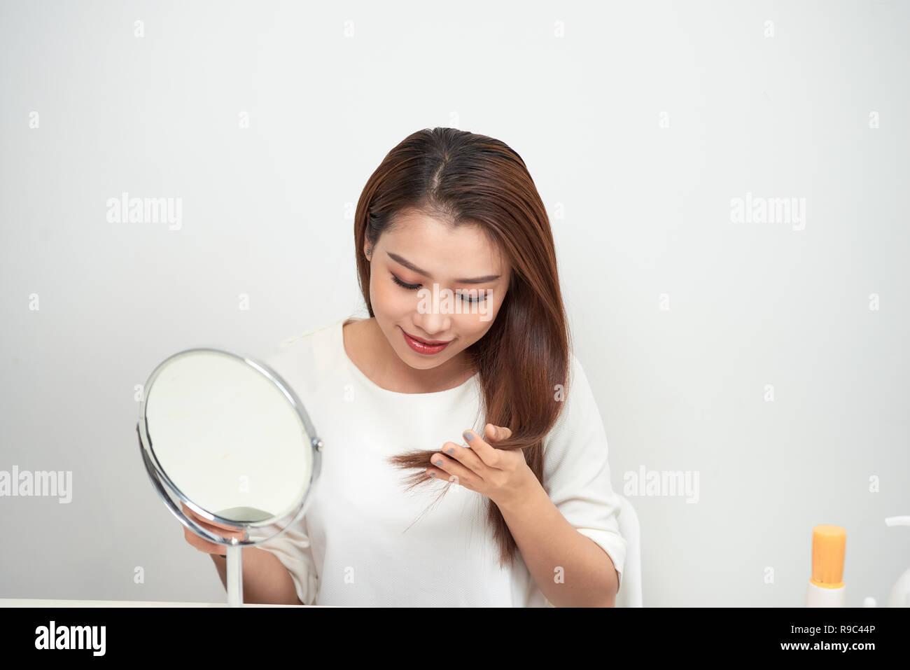Isolated portrait of a beautiful young woman comb long hair Stock Photo