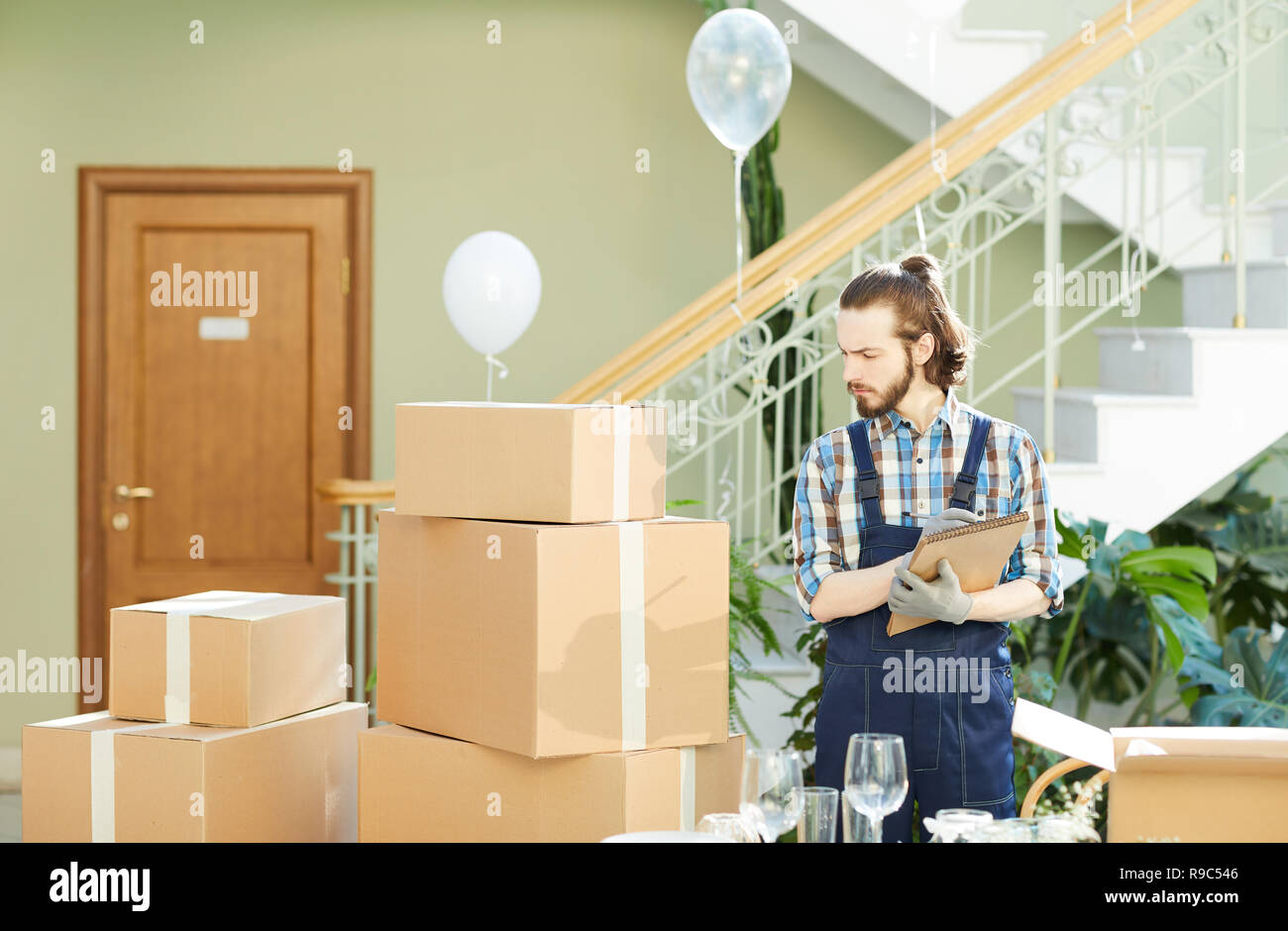 Thoughtful mover verifying existence of goods Stock Photo