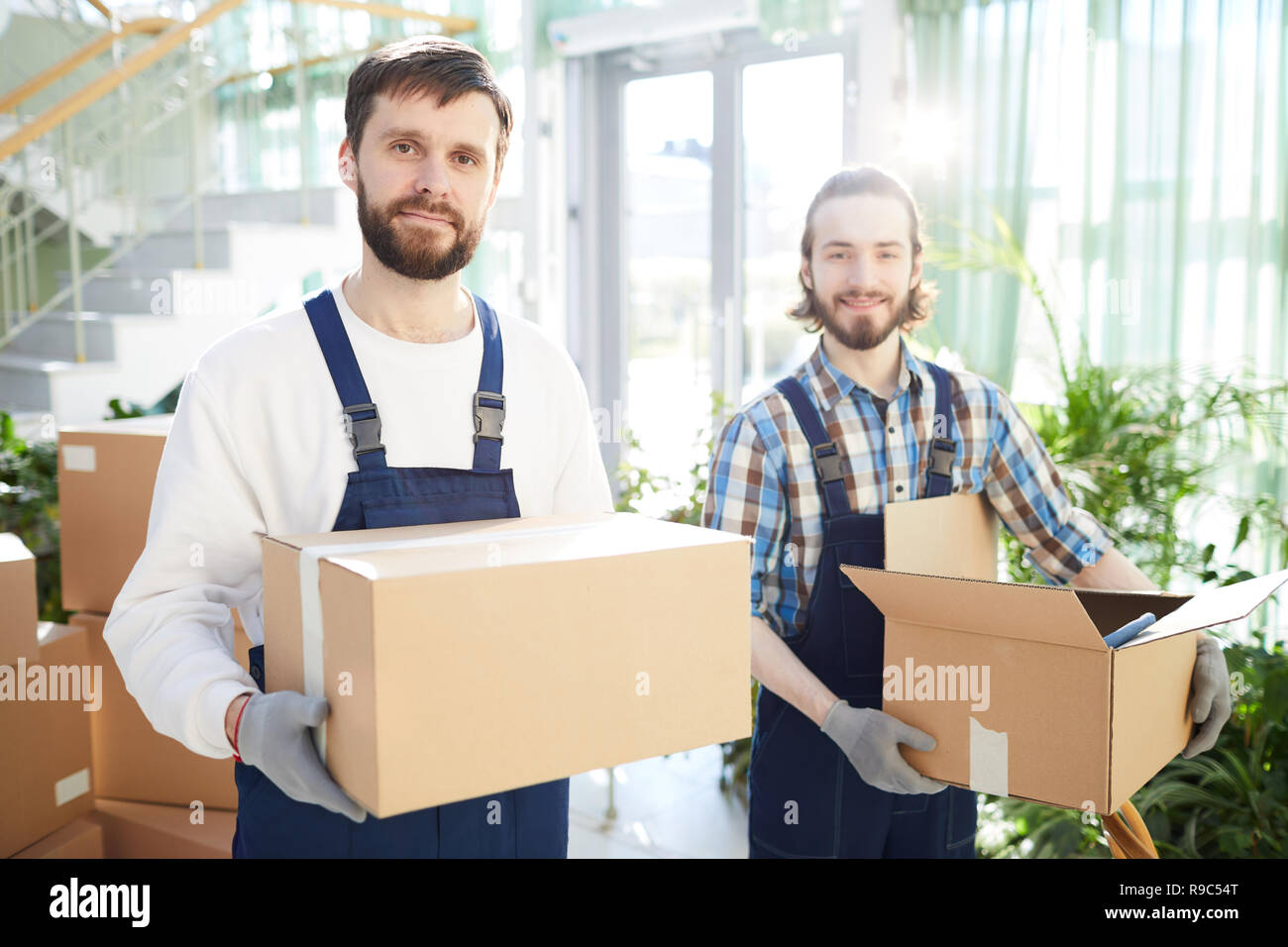 Positive movers carrying boxes Stock Photo Alamy