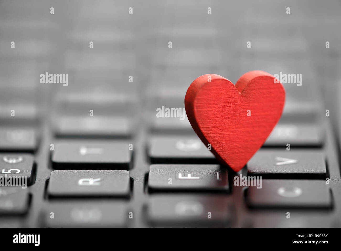 Small red heart on keyboard. Internet dating concept. Stock Photo