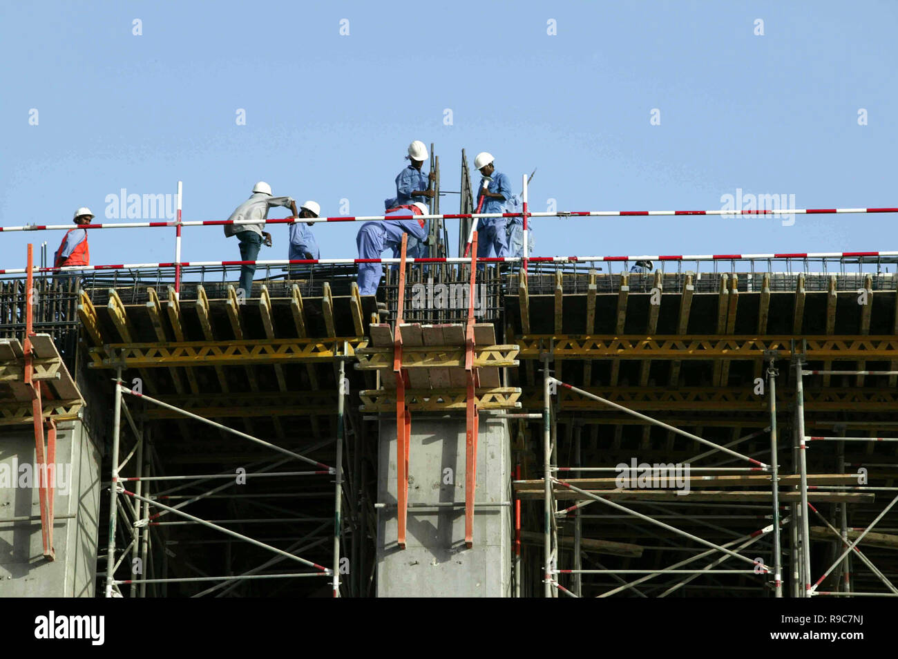 Dubai, United Arab Emirates, UAE - 14JUN2004: Workers silhouetted during the late afternoon while laying a building foundation in the Dubai Marina area which was a hub of hundreds of major construction projects, during the boom times. Stock Photo