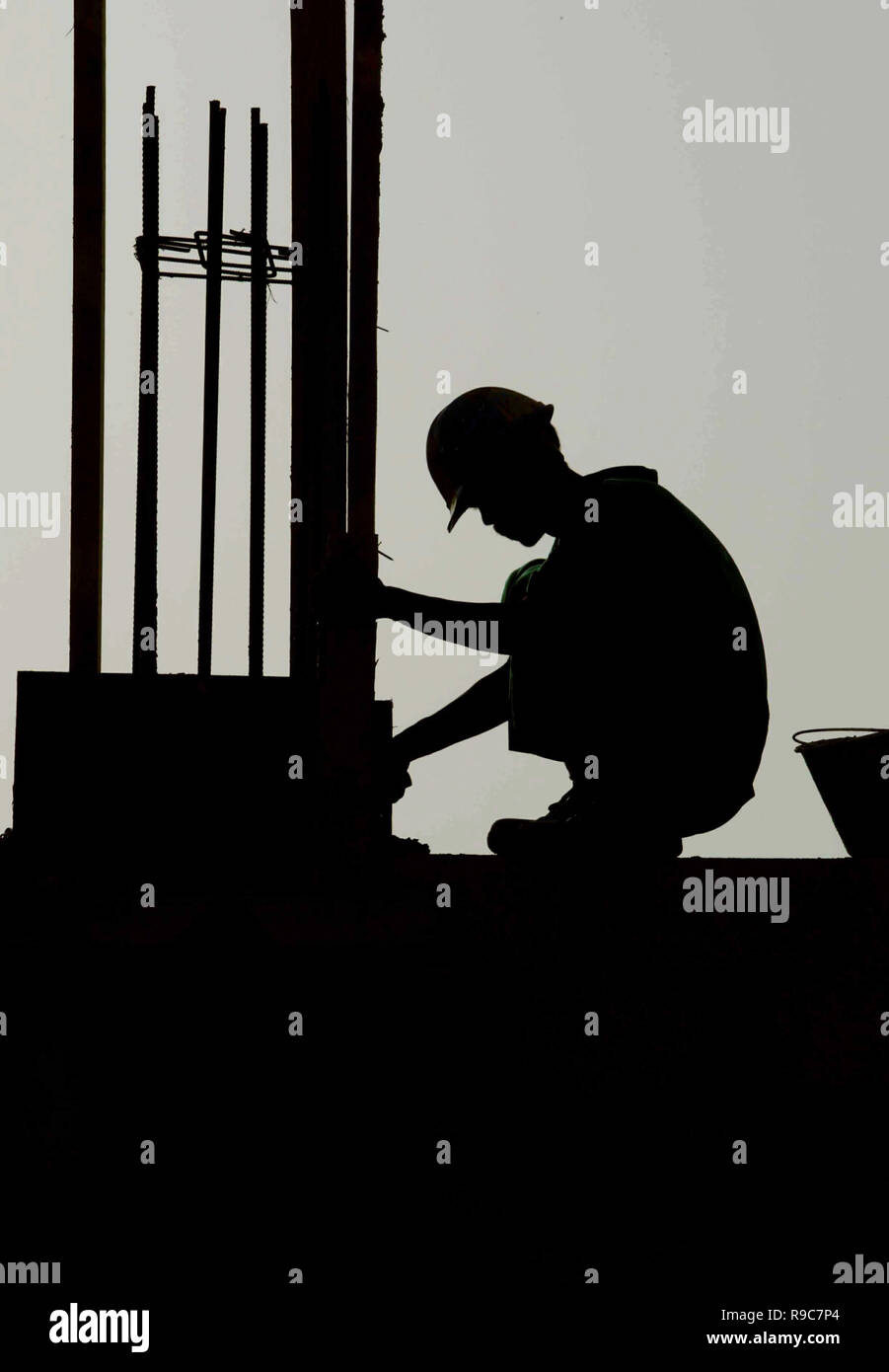 Dubai, United Arab Emirates, UAE - 14JUN2004: Worker silhouetted during the late afternoon while laying a building foundation in the Dubai Marina area which was a hub of hundreds of major construction projects, during the boom times. Stock Photo
