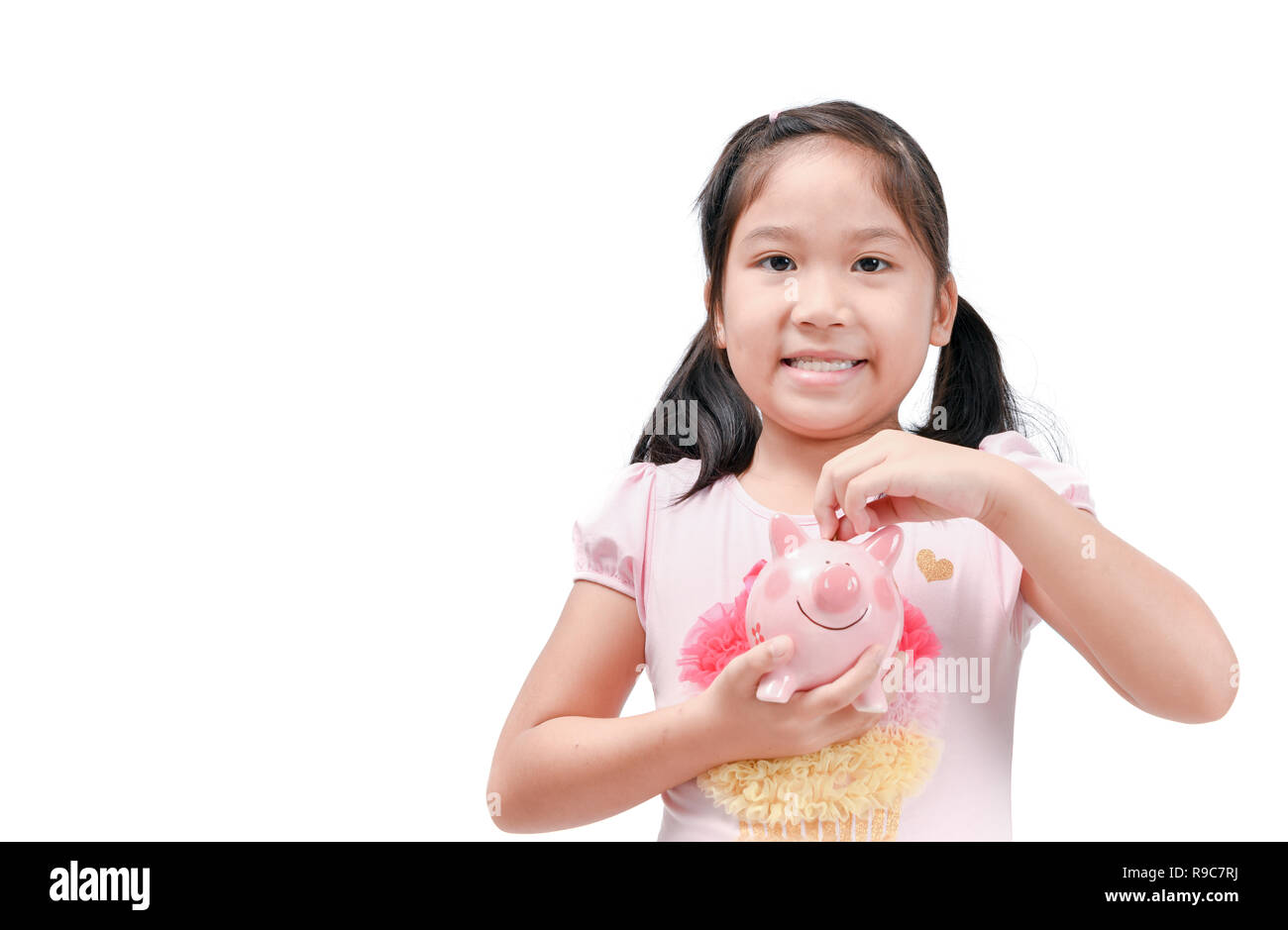 Happy cute asian girl holding pink piggy bank isolated on white ...