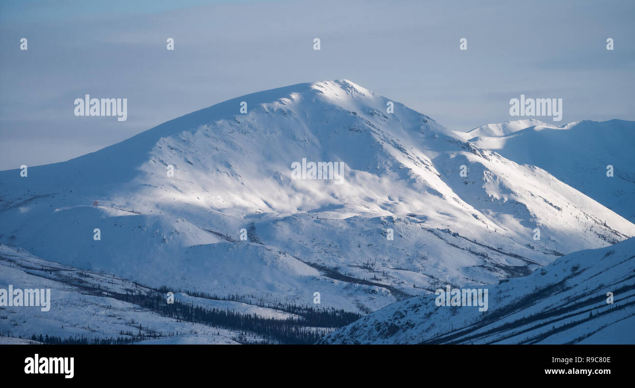 Snow covered mountain catching late afternoon light, Yukon, Canada