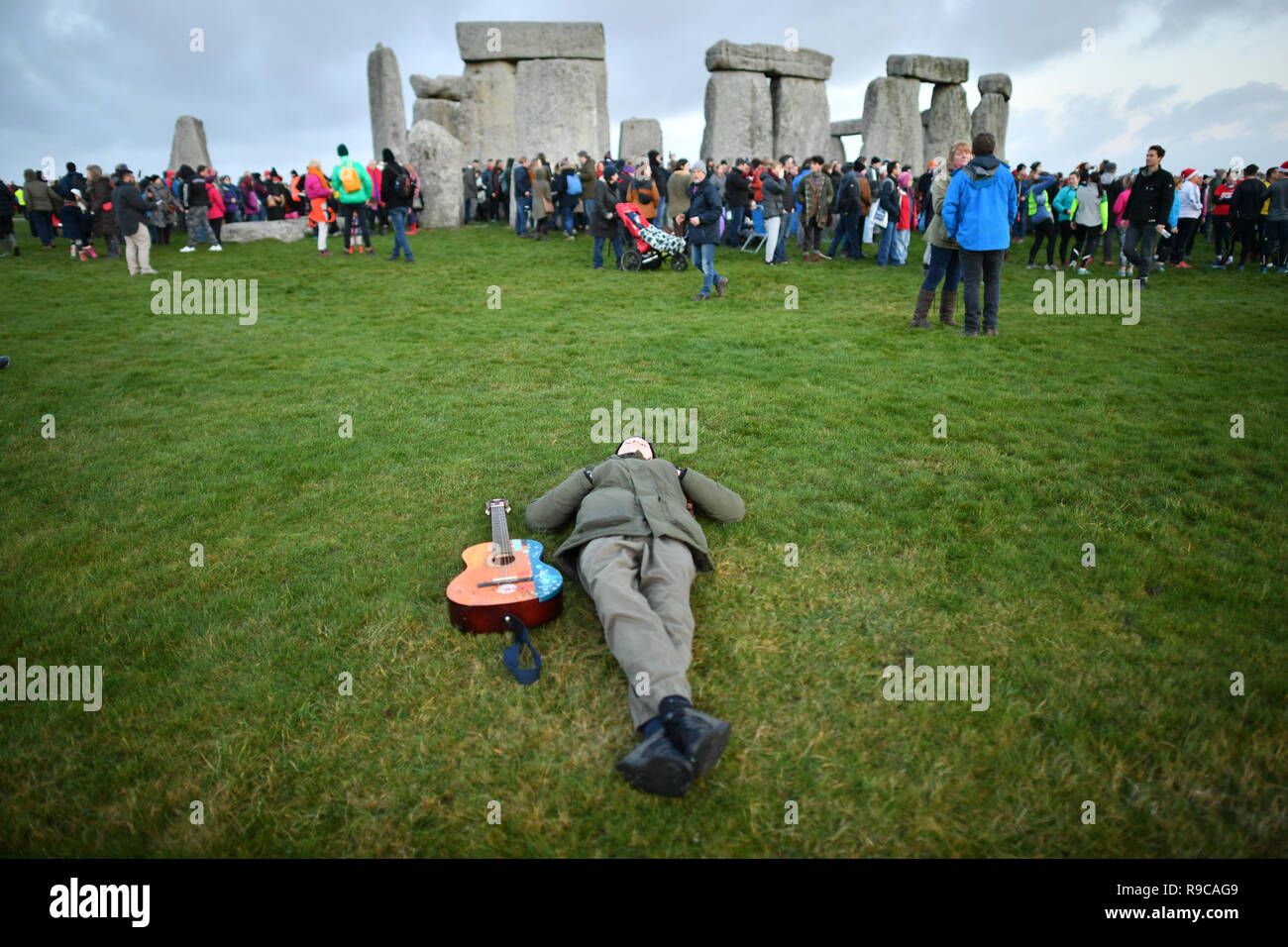 A man relaxes at Stonehenge in Wiltshire as people gather to mark the ...