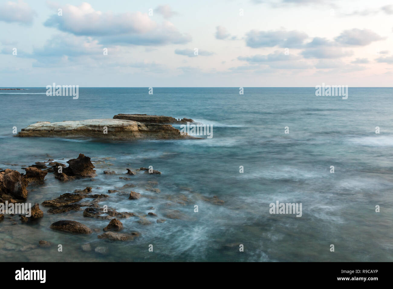 Evening time long exposure shot of stony shore of Mediterranean sea in Cyprus. Stock Photo
