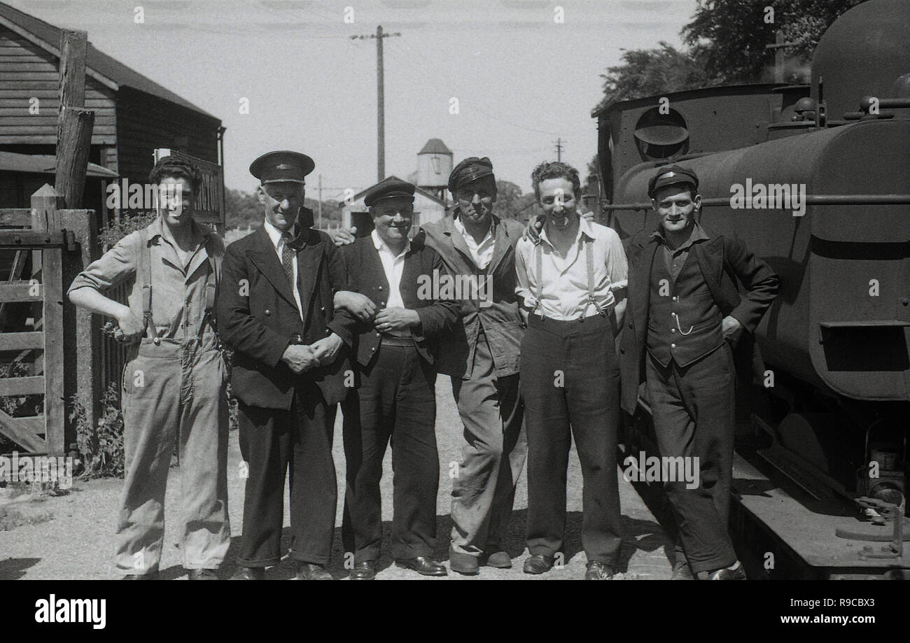 195, historical, British Railways workers including train drivers,guards and station master, stand together outside beside a steam train for a group picture. Stock Photo