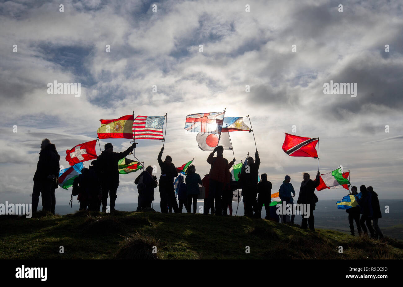 Residents of Lockerbie and others affected by the bombing climb Burnswark Hill above the town of Lockerbie in Dumfries and Galloway with 21 flags representing the 21 nationalities of the victims for the Walk for Peace event to commemorate the 30th anniversary of the air disaster. Stock Photo