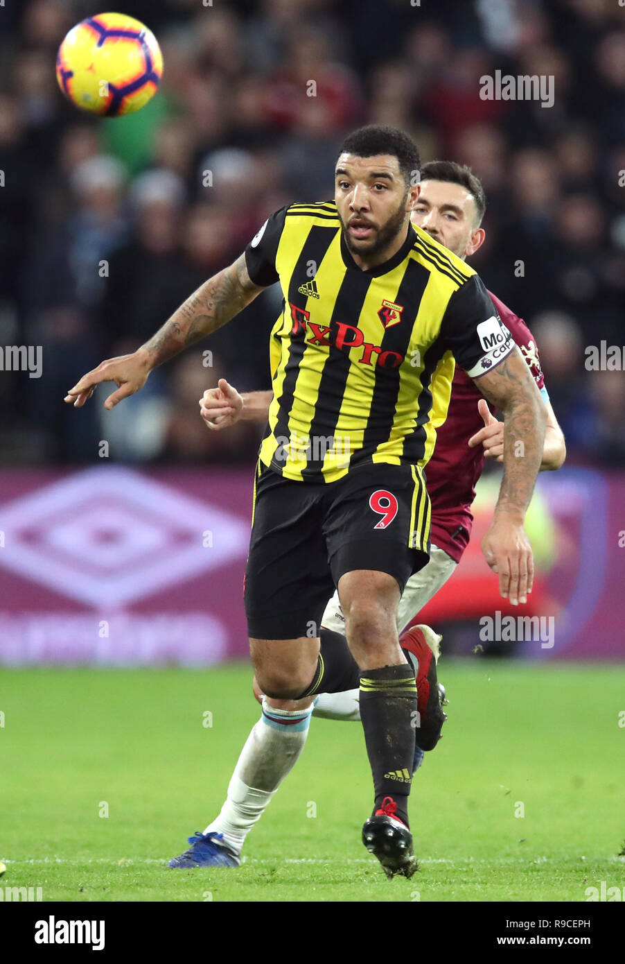 Watford's Troy Deeney (left) and West Ham United's Robert Snodgrass battle for the ball during the Premier League match at London Stadium. Stock Photo