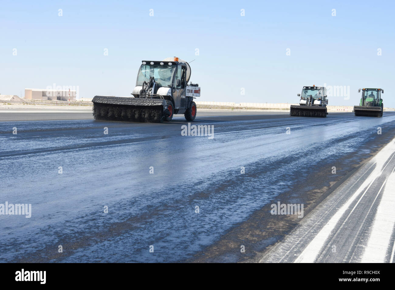 The 577th Expeditionary Prime Beef Squadron agitate Avion on the runway during the rubber removal process at Al Dhafra Air Base, United Arab Emirates, Dec. 15, 2018. Whenever an aircraft touches down on the runway, it leaves a trace of rubber the surface. Over time, excess amounts of rubber reduces aircraft braking, creating a landing hazard. (U.S. Air Force photo by Tech. Sgt. Darnell T. Cannady) Stock Photo