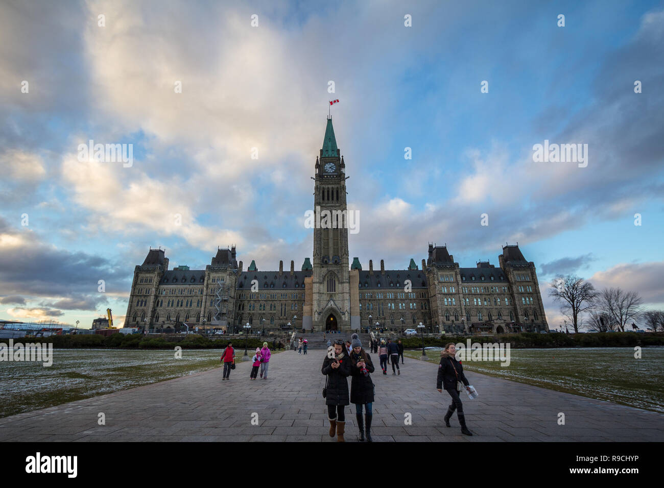 OTTAWA, CANADA - NOVEMBER 10, 2018: Tourists standing on front of the center bloc of the Parliament of Canada, with its Main clock tower. in the Canad Stock Photo