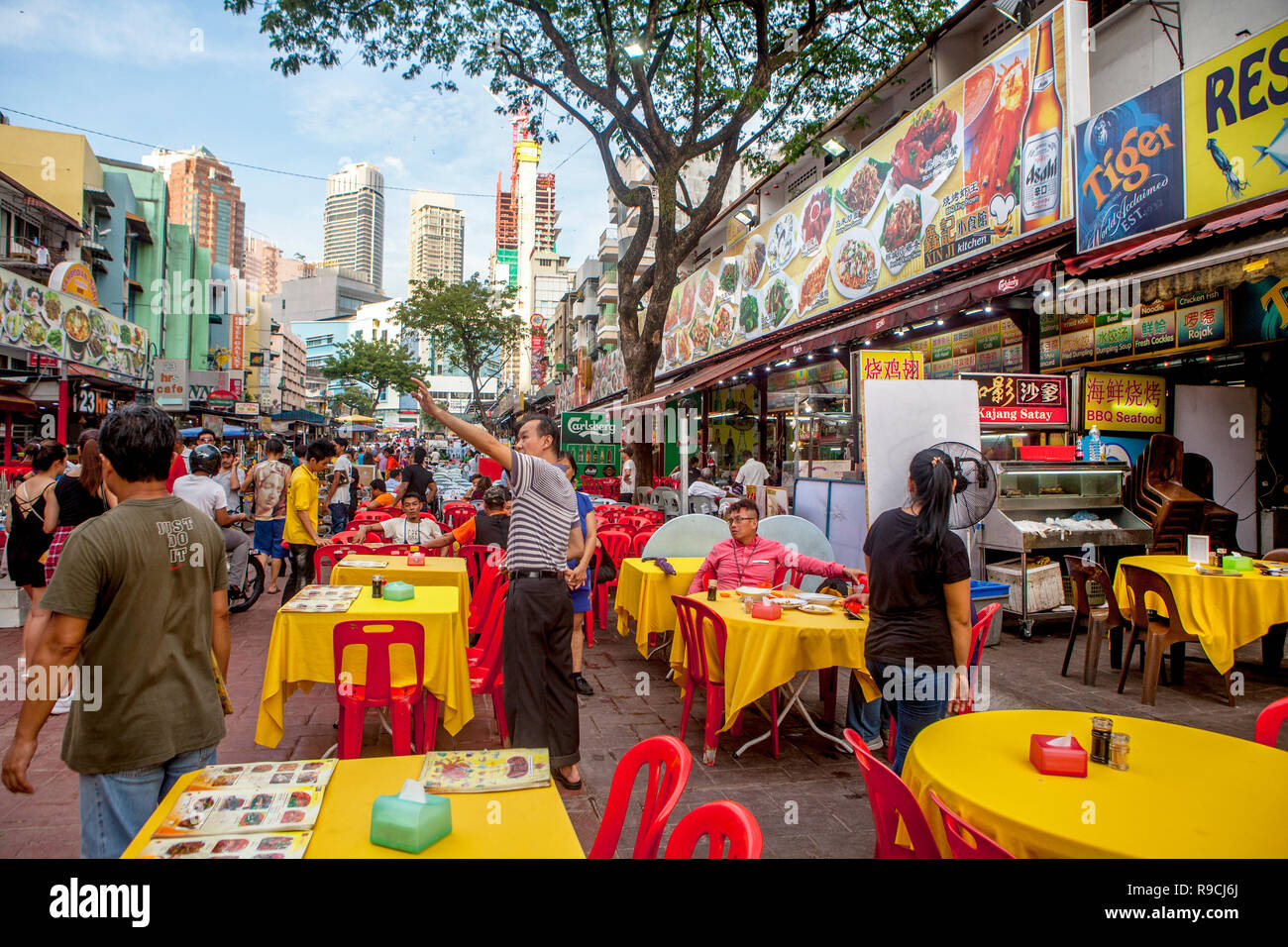 Tourists eat at outdoor restaurants at Food Street - Jalan Alor - Bukit Bintang, Kuala Lumpur, Malaysia. Stock Photo