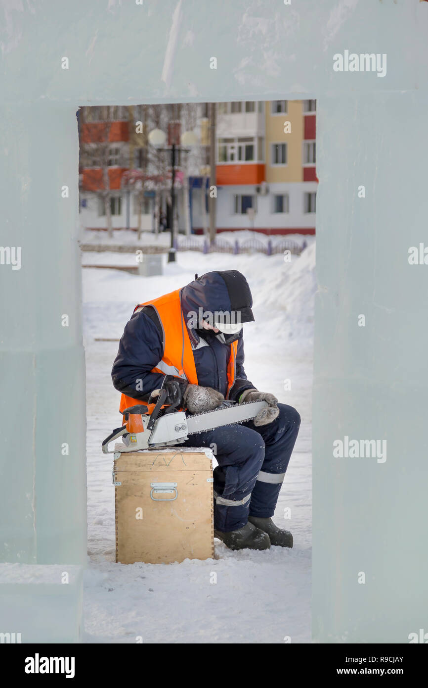 A manual file worker sharpens a chainsaw chain Stock Photo
