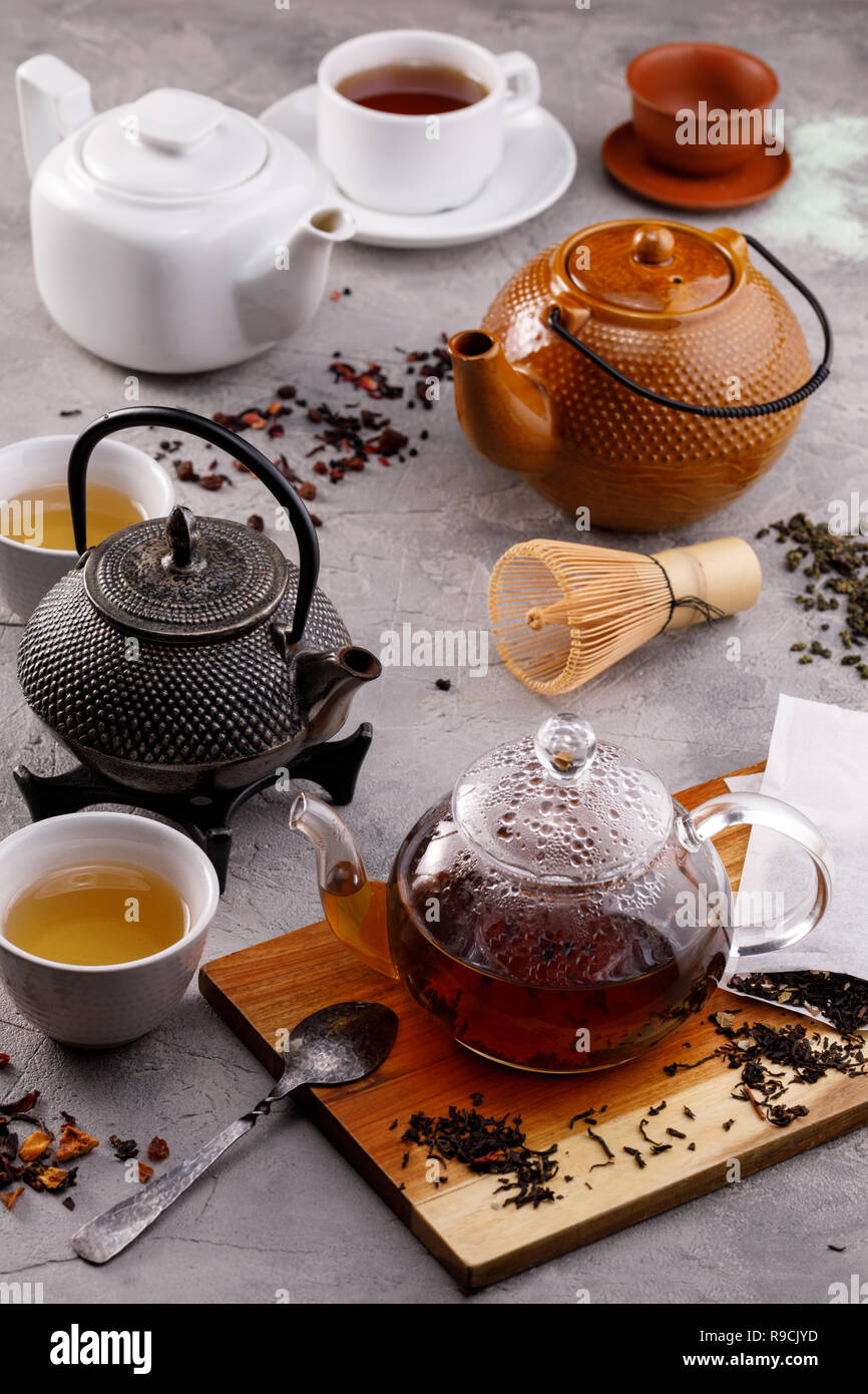 Tea card. Variety of teapots on a gray background and different types